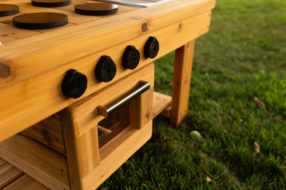Cedar outdoor mud kitchen by Noble Wooden Toys with oven, stovetop, working faucet and 2 centred stainless steel sinks