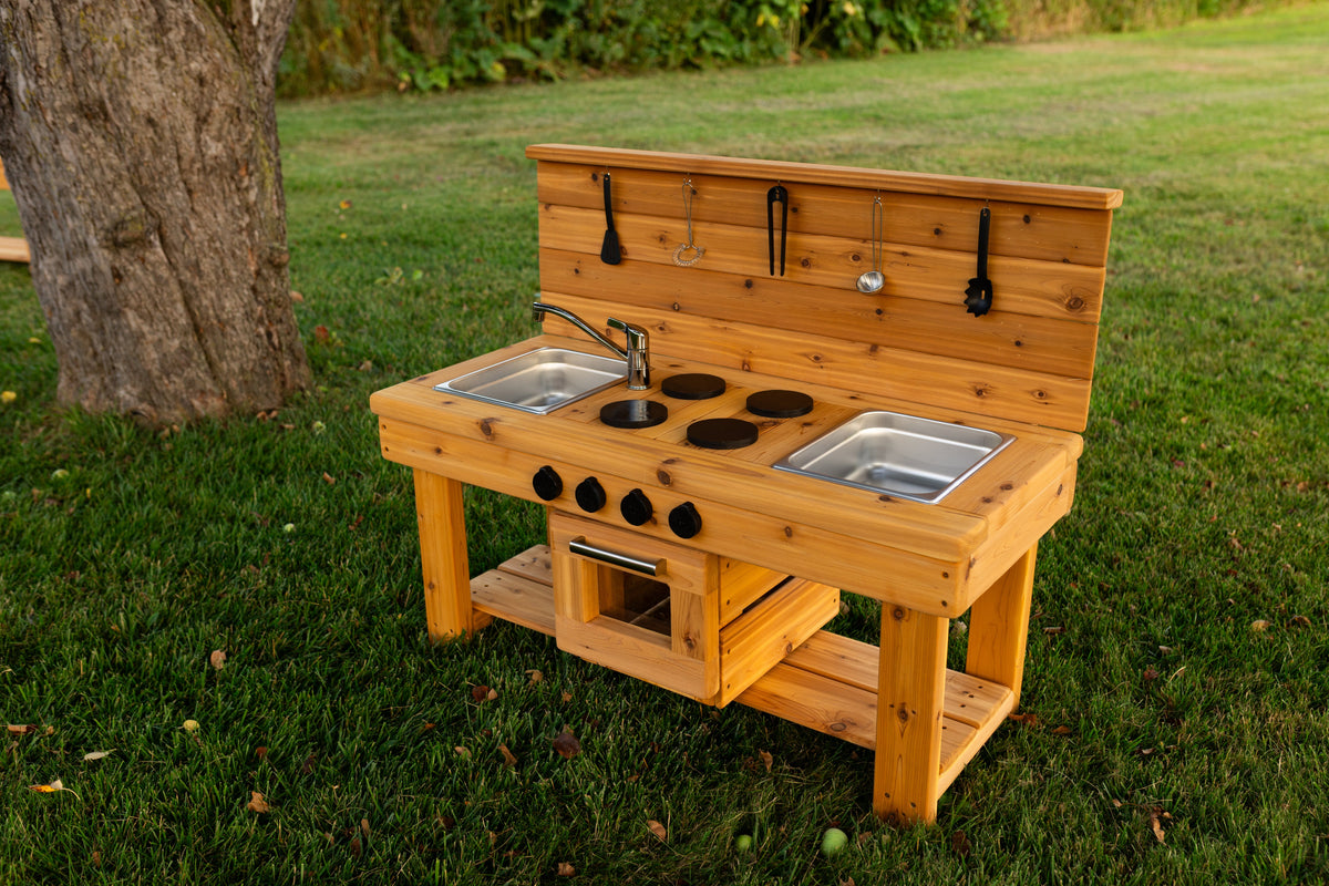 Cedar outdoor mud kitchen by Noble Wooden Toys with oven, stovetop, working faucet and 2 centred stainless steel sinks