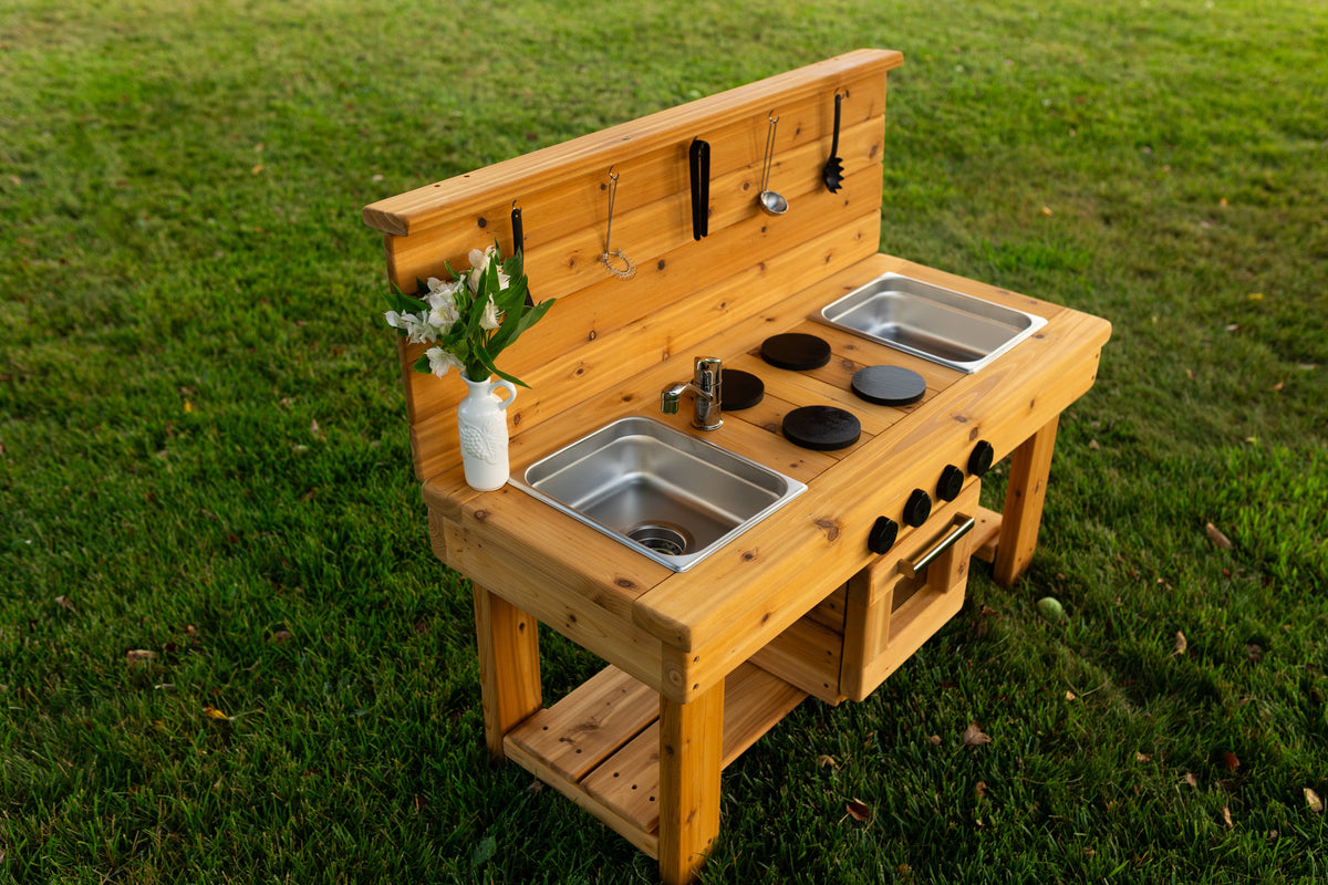 Cedar outdoor mud kitchen by Noble Wooden Toys with oven, stovetop, working faucet and 2 centred stainless steel sinks