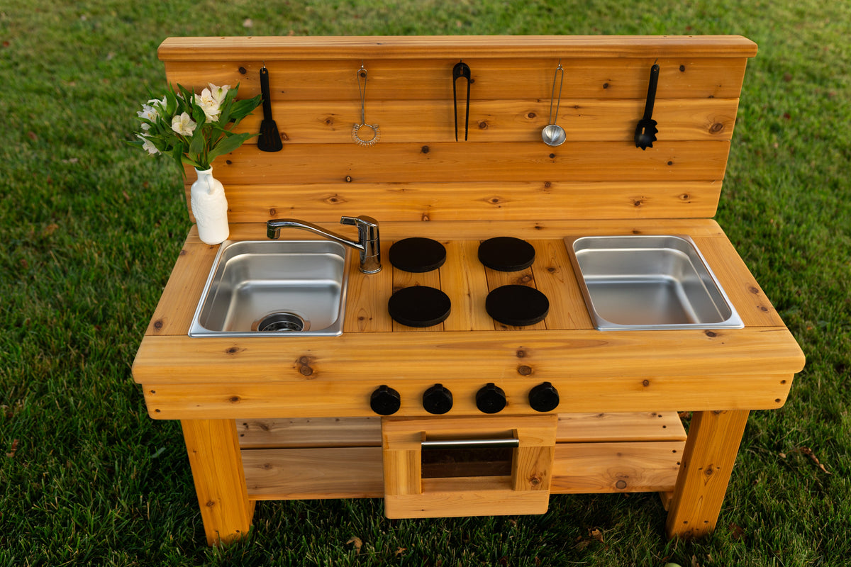 Cedar outdoor mud kitchen by Noble Wooden Toys with oven, stovetop, working faucet and 2 centred stainless steel sinks