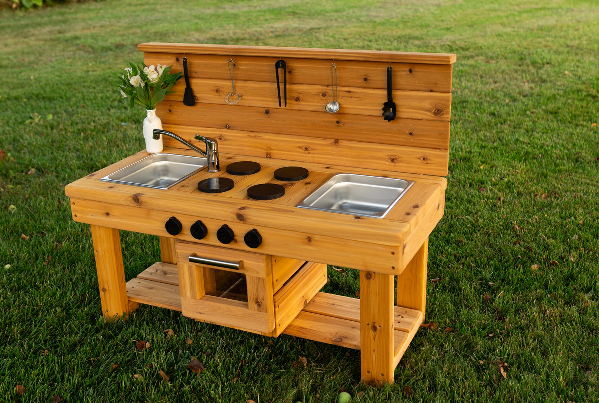 Cedar outdoor mud kitchen by Noble Wooden Toys with oven, stovetop, working faucet and 2 centred stainless steel sinks