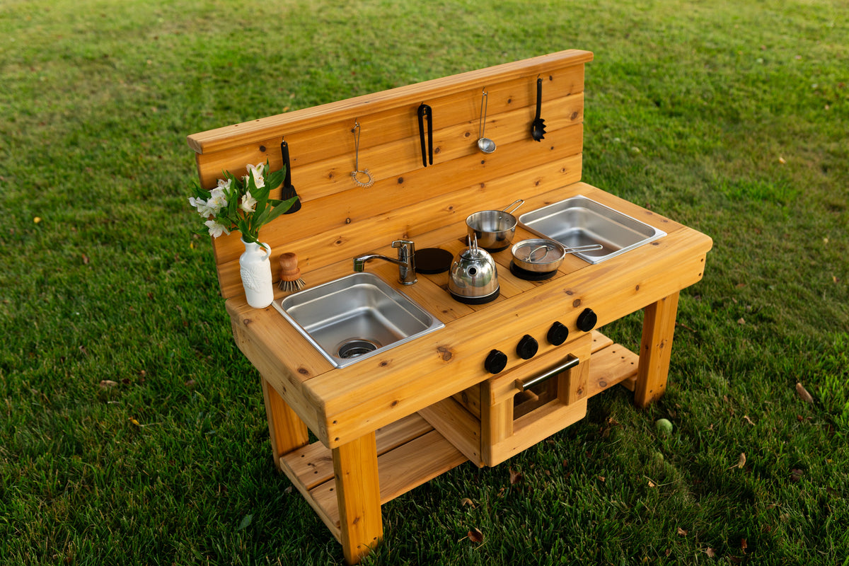 Cedar outdoor mud kitchen by Noble Wooden Toys with oven, stovetop, working faucet and 2 centred stainless steel sinks