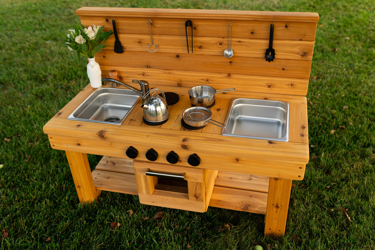 Cedar outdoor mud kitchen by Noble Wooden Toys with oven, stovetop, working faucet and 2 centred stainless steel sinks