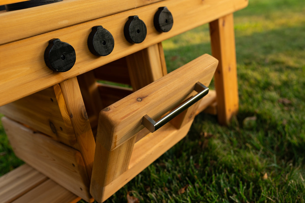Cedar outdoor mud kitchen by Noble Wooden Toys with oven, stovetop, working faucet and 2 centred clear sinks