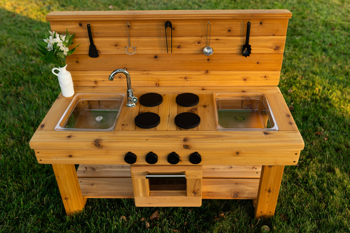 Cedar outdoor mud kitchen by Noble Wooden Toys with oven, stovetop, working faucet and 2 centred clear sinks