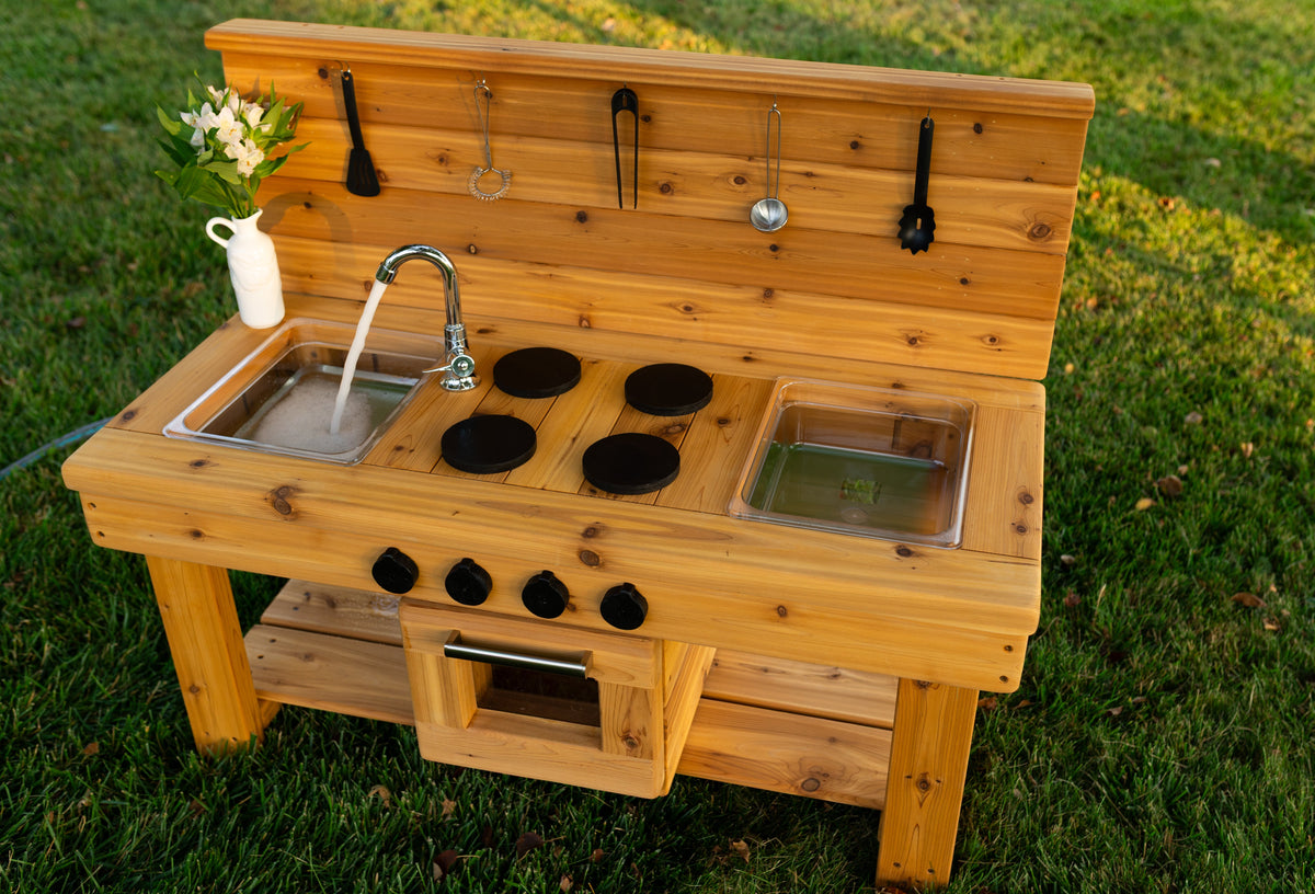 Cedar outdoor mud kitchen by Noble Wooden Toys with oven, stovetop, working faucet and 2 centred clear sinks