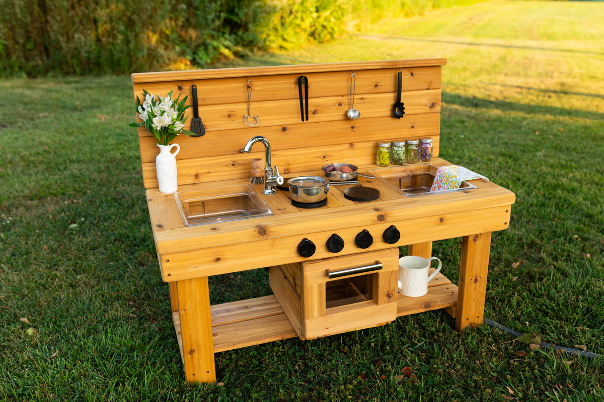 Cedar outdoor mud kitchen by Noble Wooden Toys with oven, stovetop, working faucet and 2 centred clear sinks