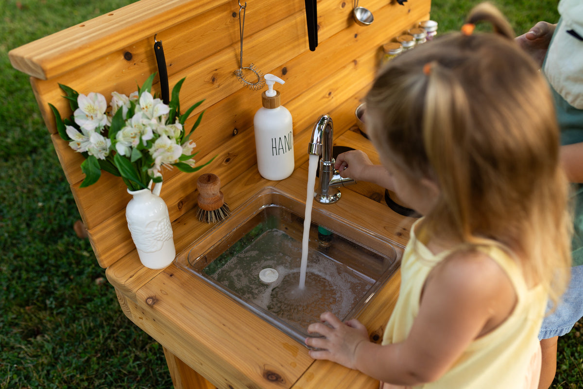 Cedar outdoor mud kitchen by Noble Wooden Toys with oven, stovetop, working faucet and 2 centred clear sinks