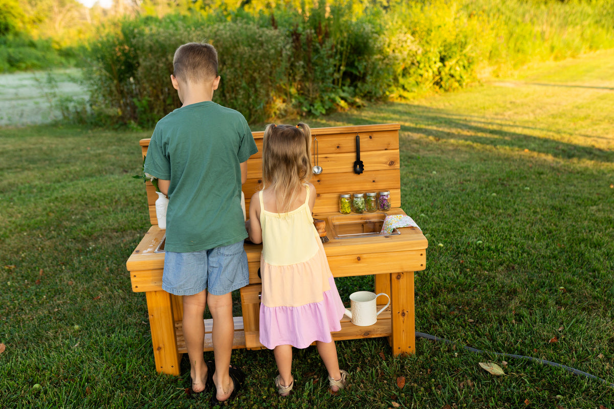 Cedar outdoor mud kitchen by Noble Wooden Toys with oven, stovetop, working faucet and 2 centred clear sinks