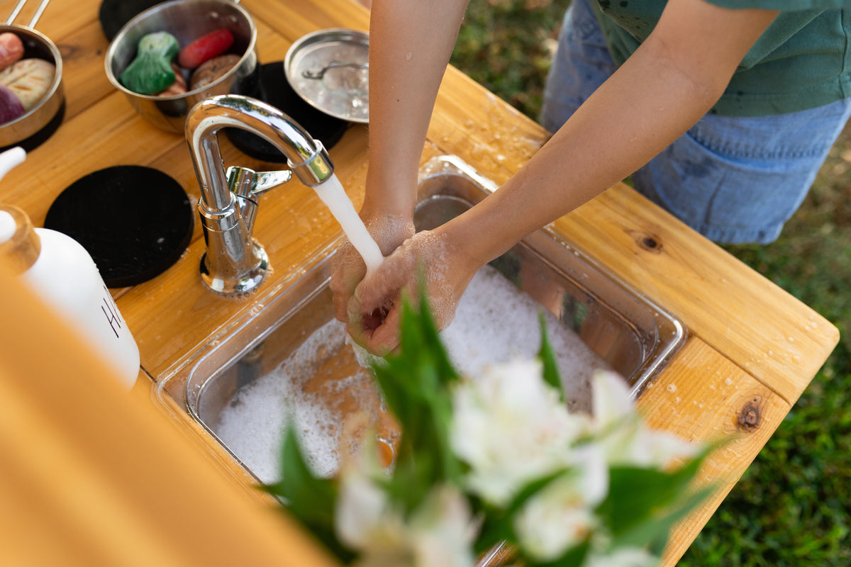 Cedar outdoor mud kitchen by Noble Wooden Toys with oven, stovetop, working faucet and 2 centred clear sinks