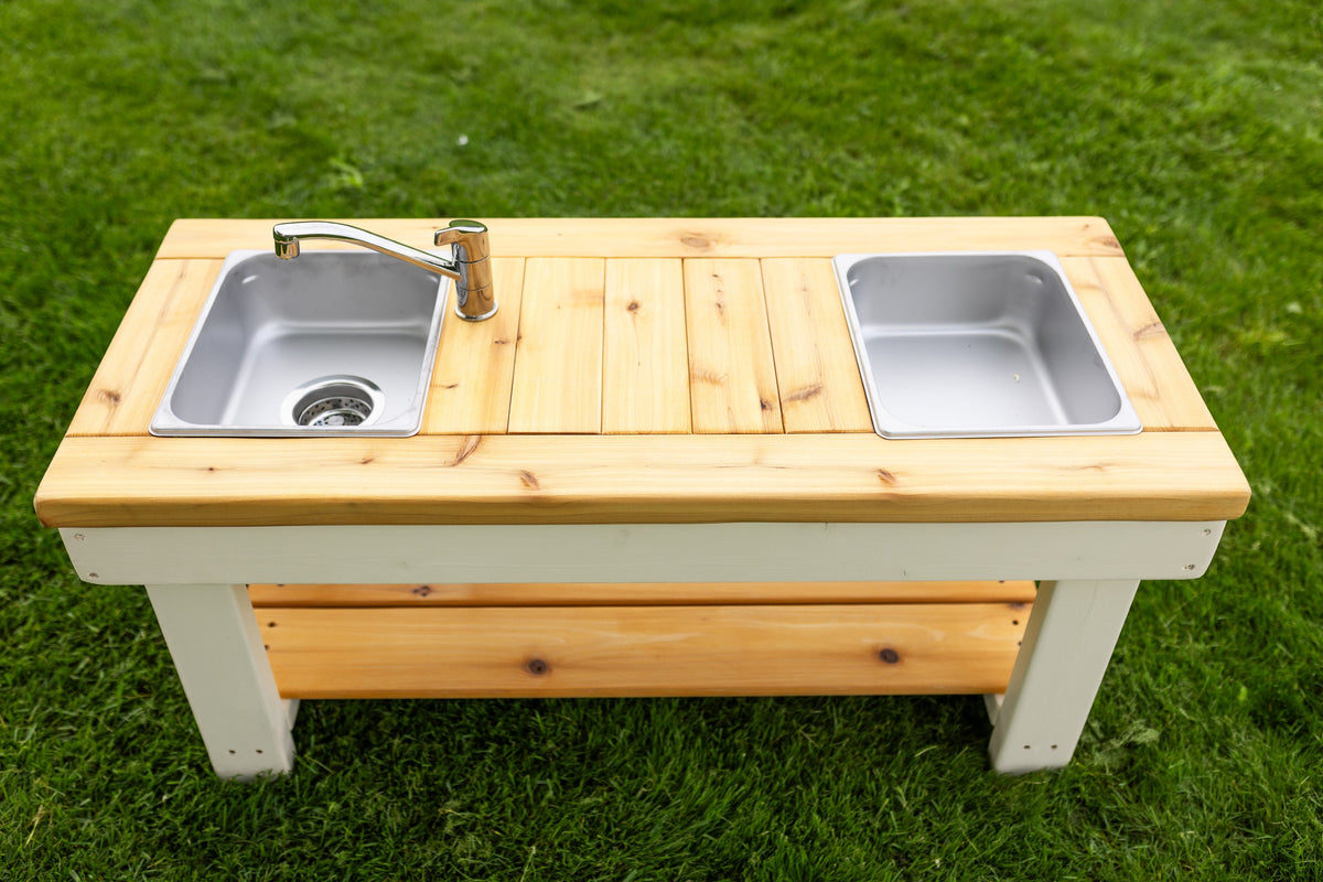 Simple painted cedar outdoor mud kitchen by Noble Wooden Toys with shelf and 2 centred stainless steel sinks